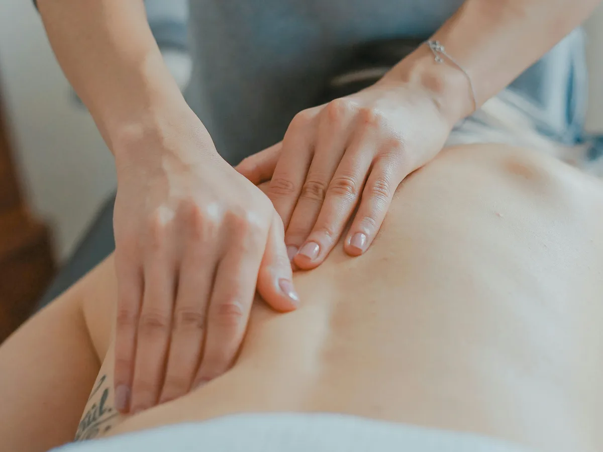 A therapist's hands working along a patient's back during a massage